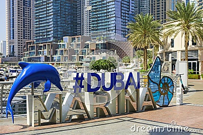 Dubai, UAE, Sep 2022. Modern colorful art installation hashtag Dubai Marina logo on Marina walk promenade. Editorial Stock Photo