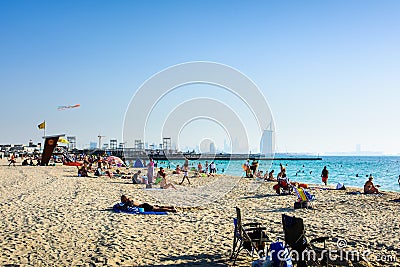 Dubai, United Arab Emirates, April 20, 2018: Kite beach in Dubai with many visitors and Burj Al Arab hotel in the background Editorial Stock Photo