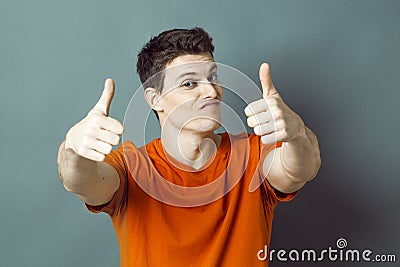 Dubious athletic man with orange t-shirt and thumbs up for success Stock Photo