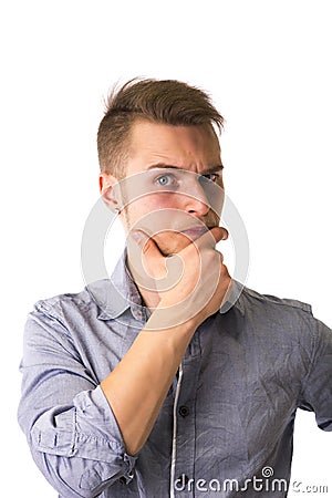 Dubious, unsure handsome blond young man Stock Photo