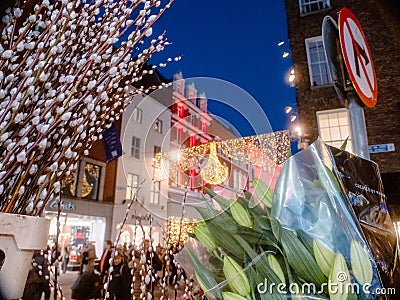 Dublin, Ireland - 20.12.2022: Flowers bouquet in focus and Decorated and illuminated Grafton street in the Irish capital out of Editorial Stock Photo
