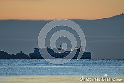 Beautiful early morning view of Stena Line ferry ship in Irish Sea near Baily lighthouse seen from Blackrock beach Editorial Stock Photo