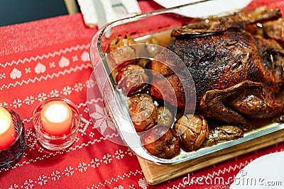 Duck baked until crispy with potatoes and apples on the Christmas table. Stock Photo