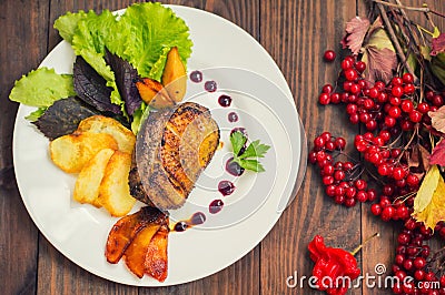 Duck breast with potato chips, herbs, sauce and caramelized apples. Wooden rustic table. Top view. Close-up Stock Photo