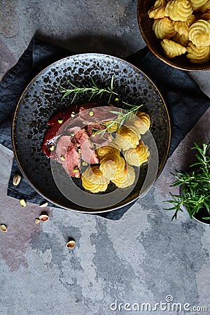 Duck breasts with Pommes Duchesse, cranberry sauce and pistachios Stock Photo