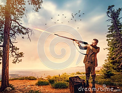 Duck hunter in hunting clothing aims an old rifle Stock Photo