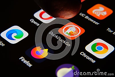 DuckDuckGo internet browser app surrounded by competitors and finger of user selecting it. Concept for competition. Editorial Stock Photo