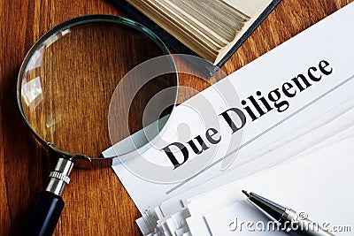 Due Diligence concept. Stack of documents and magnifying glass Stock Photo