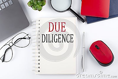 DUE DILIGENCE text on a notepad with laptop on the white background Stock Photo