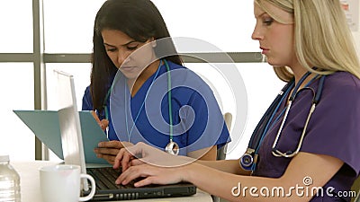Due infermieri femminili con lavoro di squadra della mostra del computer portatile video d archivio Due infermieri femminili con lavoro di squadra della mostra del computer portatile video d archivio