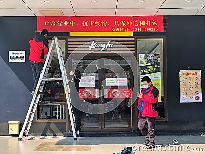 Due to Wuhan pneumonia, employees are hang banner at Real Kungfu Restaurant, only provide catering takeaway services. Editorial Stock Photo