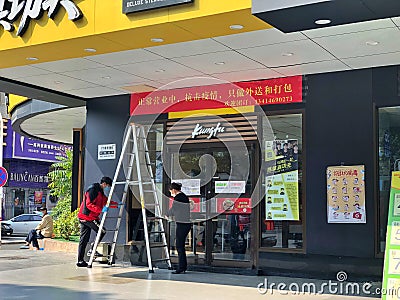 Due to Wuhan pneumonia, employees are hang banner at Real Kungfu Restaurant, only provide catering takeaway services. Editorial Stock Photo