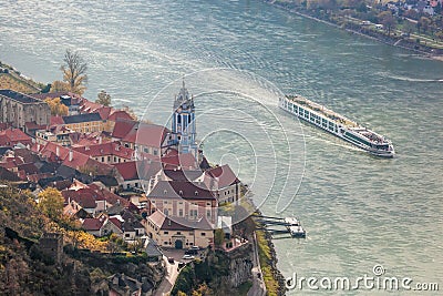 Duernstein village with castle against tourist boat on Danube river during autumn, Wachau in Austria Stock Photo