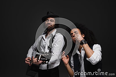 duet of expressive musicians playing acoustic guitar and harmonica Stock Photo