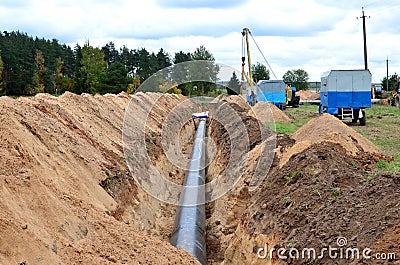 A Dug trench in the ground for the installation and installation of industrial gas and oil pipes Stock Photo