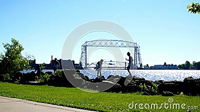 Duluth Minnesota - Juli 2, 2018: Historisk iconic flyg- elevatorbro och kanal med att spela för barn lager videofilmer Duluth Minnesota - Juli 2, 2018: Historisk iconic flyg- elevatorbro och kanal med att spela för barn lager videofilmer