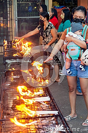 Filipinos gather to pray and light religious candles,at a holy shrine next to the iconic Dumaguete Belfry,that helped save the Editorial Stock Photo