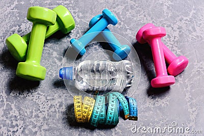 Dumbbells made of pink, green and cyan plastic Stock Photo