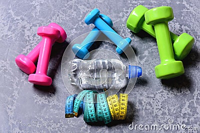 Dumbbells made of pink, green and cyan plastic Stock Photo