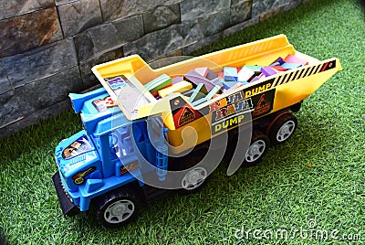 Dumper toy transporting multi colored wooden blocks Editorial Stock Photo