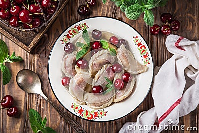 Dumplings with cherry Vareniki, pierogi, rustic background Stock Photo