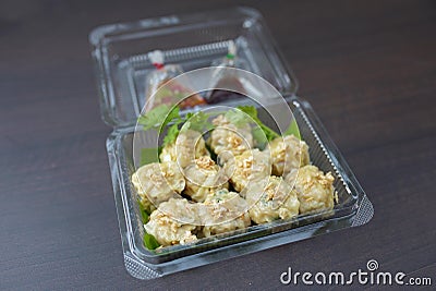 Dumplings in a clear plastic packaging on the brown background. Stock Photo