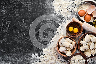 Dumplings with potatoes. Vareniki Homemade. Flour, eggs, dough on a black background. Stock Photo
