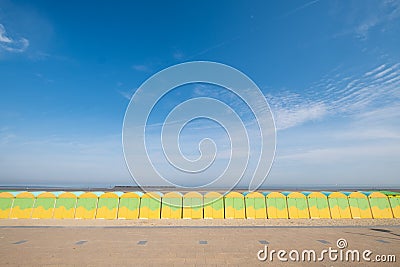 Dunkerque, France: Quirky green and yellow beach cabins on the sea front at Malo-Les-Bains beach in Dunkirk. Stock Photo