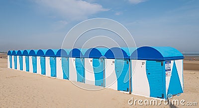 Dunkerque, France: Row of blue and white striped beach huts on the sea front at Malo-Les-Bains beach in Dunkirk Editorial Stock Photo