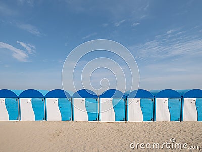 Dunkerque, France: Row of blue and white striped beach huts on the sea front at Malo-Les-Bains beach in Dunkirk Editorial Stock Photo