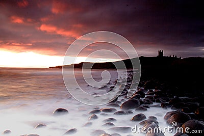 Dunstanburgh Castle coastline Stock Photo