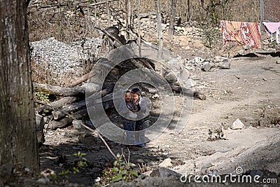 Duo Yi Shu Village, Yunnan, China: Two poor children are smiling in an abandoned place Editorial Stock Photo