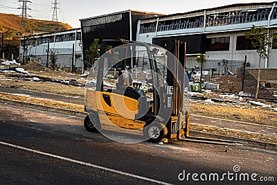 Durban, South Africa, 14 July 2021. Forklift in front of a burnt building. Editorial Stock Photo