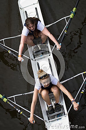 Two female rowers in race with one looking up to camera. Overhead shot Editorial Stock Photo