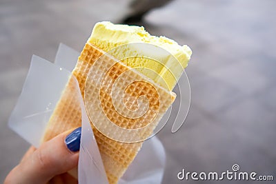 Durian Ice Cream in a waffle in a woman`s hand, made of Durian Durio, asian fruit having strong, smelly odour Stock Photo