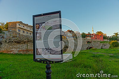 DURRES, ALBANIA: Exterior of ancient Roman amphitheater with surrounding buildings in the city of Durres. Editorial Stock Photo