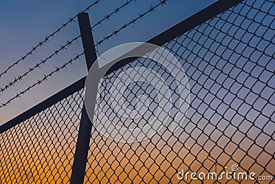 Dusk twilight evening sky with fences and barbed wire Stock Photo