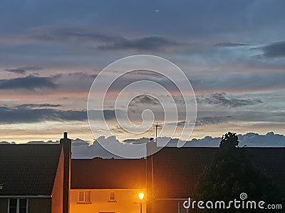 Dusk wall of clouds sunset town streetlight Stock Photo