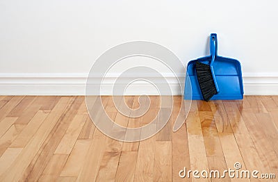 Dustpan and brush on a wooden floor Stock Photo