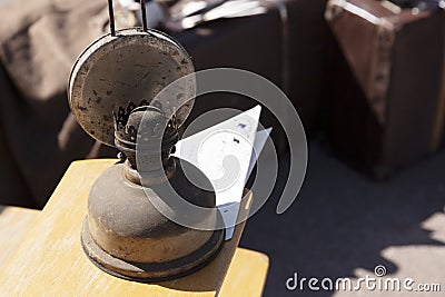 Dusty, antique, kerosene lamp against the background of an old suitcase Stock Photo