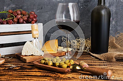 Dusty bottle of red wine on a wooden table Stock Photo