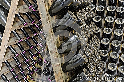 Dusty bottles with brut sparkling wine on wooden rack Stock Photo