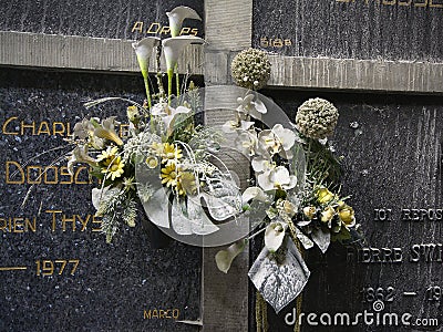 Dusty fake flowers on old grave stones Editorial Stock Photo