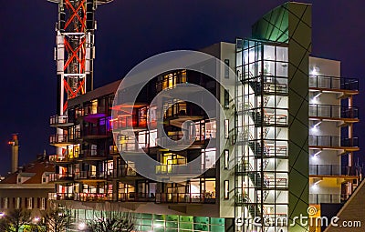 Dutch architecture by night, lighted apartments building with staircase and balconies Editorial Stock Photo