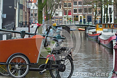 Dutch bicycle or bakfiets at Amsterdam street canal with bridge background Stock Photo