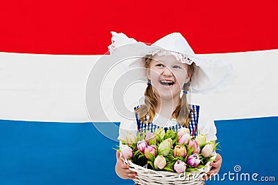 Dutch child with tulip flowers and Netherlands flag Stock Photo