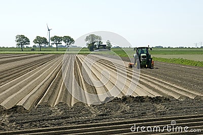 Dutch farmer makes potato ridges in cropland Editorial Stock Photo