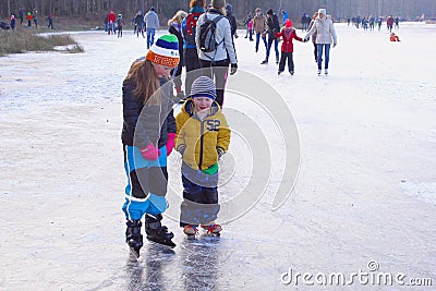 Dutch girl little brother ice skate lessons frozen lake, Netherlands Editorial Stock Photo