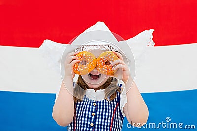 Dutch girl with orange donuts and Netherlands flag Stock Photo