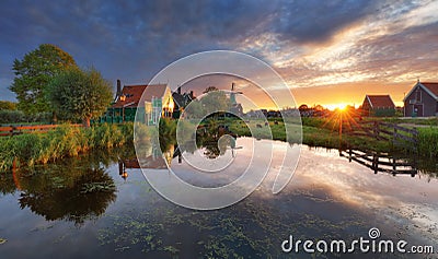 Dutch landscape with windmill at dramatic sunset, Zaandam, Amsterdam, Netherlands Stock Photo